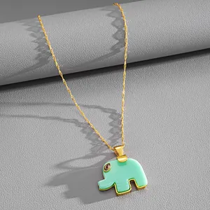 Macro view of a gold-plated necklace featuring a mint green resin elephant pendant charm