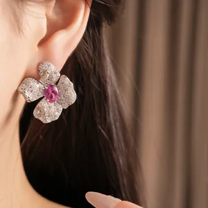 Detailansicht eines eleganten rosa Blumenohrrings mit Zirkonia-Besatz am Modell