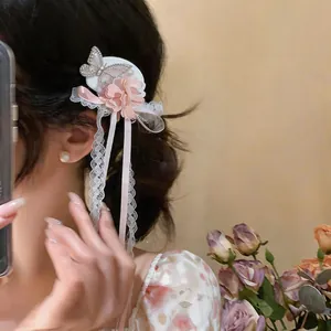 Close-up of a sweet French style hair clip with chiffon flower and butterfly ribbons