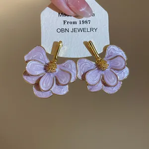 Detail of purple oil-drip flower stud earrings with gold-tone accents