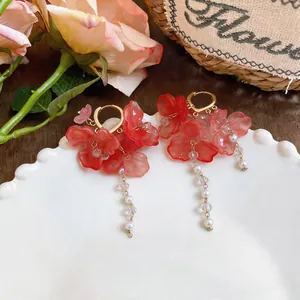 Close-up of elegant red flower tassel earrings with white imitation pearls and beads