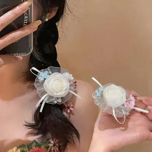 Detail of elegant white chiffon flower hair clip with pearls and ribbon decoration