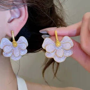 Close-up of elegant purple enamel flower stud earrings with gold-toned center.