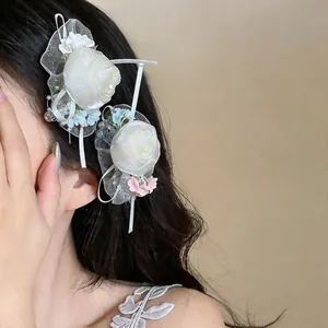 Close-up of white chiffon flower hair clips with delicate pearls worn for French sweet style