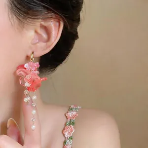 Detailed view of elegant pink flower tassel earrings featuring faux pearl accents.