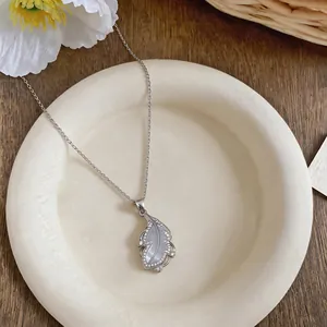 Macro view of an elegant zircon-studded feather necklace with delicate mother-of-pearl inlay