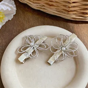 Eleganti fermagli per capelli con perle e fiori traforati su un piatto decorativo