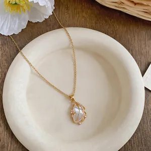 Detail of 18k gold plated feather necklace with zircon and mother of pearl inlay