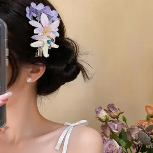 Detail view of a French style chiffon flower hair clip with starfish element on model