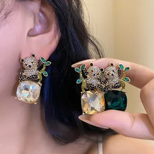 Close-up of cute panda earrings featuring square gemstone drops and sparkling rhinestones.