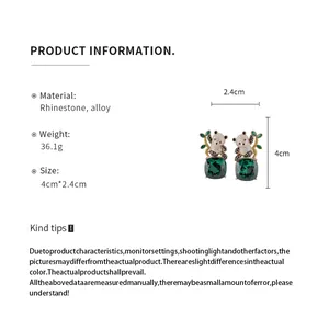 Macro view of product specifications for panda stud earrings with green square gems (84 chars)