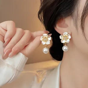 Close-up view of vintage floral earrings with elegant pearl drop
