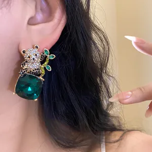Detailed view of exquisite panda earring featuring a large square emerald green crystal