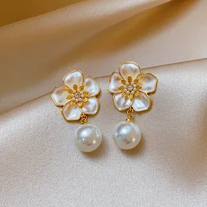 Detail of French retro flower stud earrings with elegant pearl drop and zircon center