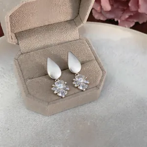 Detail view of elegant silver teardrop earrings with sparkling flower-shaped zirconia