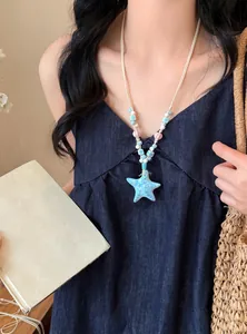 Close-up of a blue starfish beaded necklace on a model for a beach vacation look