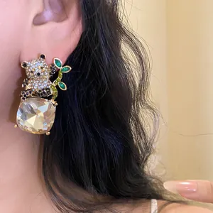 Close-up detail of a sparkling panda earring featuring a large faceted square crystal pendant.