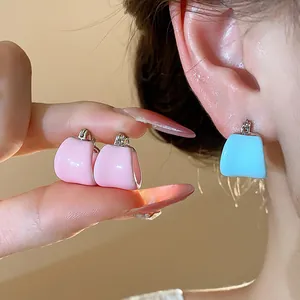 Gros plan détaillé de créoles en émail rose et bleu en forme de U au fini brillant