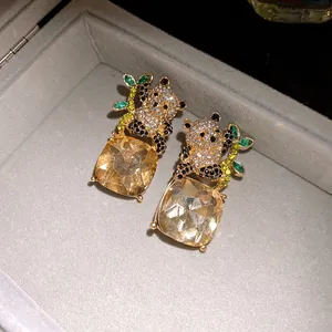 Detail shot of panda-shaped silver stud earrings with square-cut champagne gems