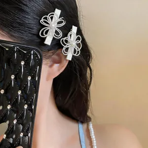 Dettaglio ravvicinato di eleganti fermagli per capelli a fiore cavo con perle