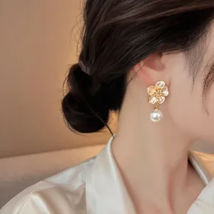 Close-up detail of a French vintage floral pearl drop earring worn on an Asian model's ear