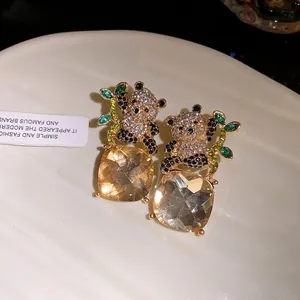 Exquisite detail of panda stud earrings featuring a large square champagne gemstone and silver needle