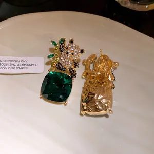 Macro view showing front and back details of panda earrings with green gemstones
