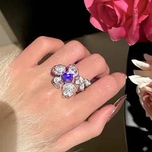 Close-up of a heavy industrial zircon flower ring with a purple center stone on hand