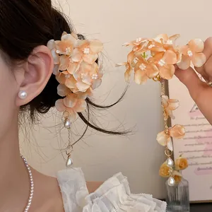 Close-up of elegant fabric flower hair clip with cascading pearl tassel details