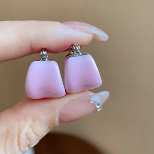 Gros plan détaillé des boucles d'oreilles créoles en émail rose en forme de U