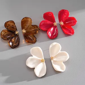 Close-up of resin flower earrings in marbled brown, vibrant red and creamy white colors