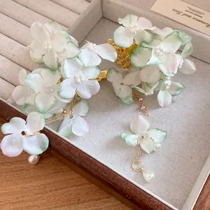 Close-up detail of handcrafted fabric flower hair clip with elegant pearl tassels