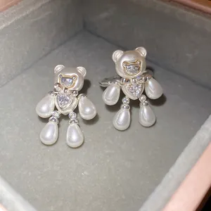 Detailed macro view of sparkling pearl bear ring and clip-on earring in a luxury jewelry box