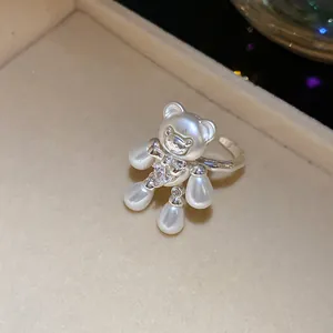 Macro detail of a silver-toned bear ring with pearl limbs and zircon accents