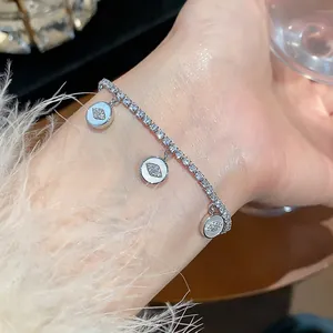 Close-up detail of a silver-toned 18k plated zircon bracelet featuring dainty evil eye charms