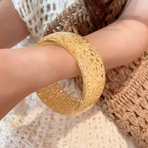 Detailed close-up showing a yellow chunky resin bangle with gold glitter on a wrist.