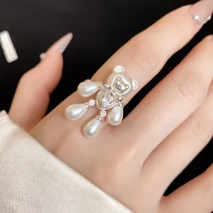Close-up of a luxury bear-shaped open ring with elegant white pearls and sparkling zircons.