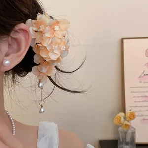Close-up of a sweet floral fabric hair clip with elegant pearl tassels on hair