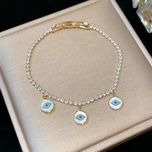 Detailed macro view of 18k gold plated bracelet with three turquoise evil eye charms