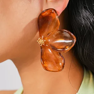 Close-up of amber resin flower earrings showing the intricate petal detail and gloss.