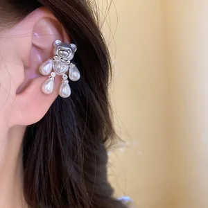 Close-up detail of a cute silver-toned teddy bear ear cuff featuring pearls and zircons