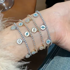 Detailed view of 18k gold plated tennis bracelets with cz evil eye charms on a wrist