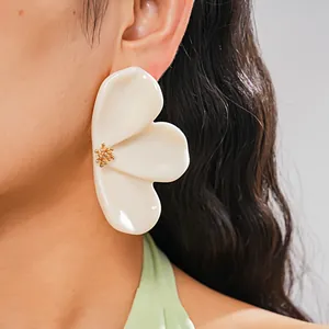 Close-up of elegant cream resin flower petal earring with a gold stamen center detail.