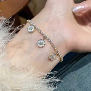 Elegant detail of 18k gold-plated bracelet featuring zircon eye charms on a wrist
