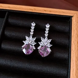 Detailed close-up of vintage purple zircon earrings with floral crystal accents