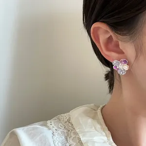Close-up view of the intricate crystal petals and pearl center of the flower earring
