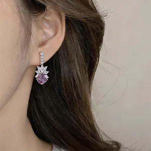 Close-up view of elegant purple zircon leaf drop earring worn by a model in detail