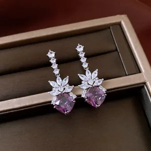 Close-up of vintage purple zircon drop earrings with marquise clear stones in a gift box