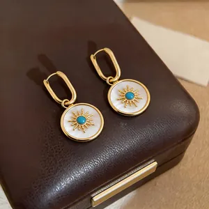Detailed macro view of vintage gold sunburst earrings with mother-of-pearl inlay