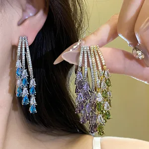 Detail view of 18k gold-plated tassel earrings featuring colorful pear-cut zircons